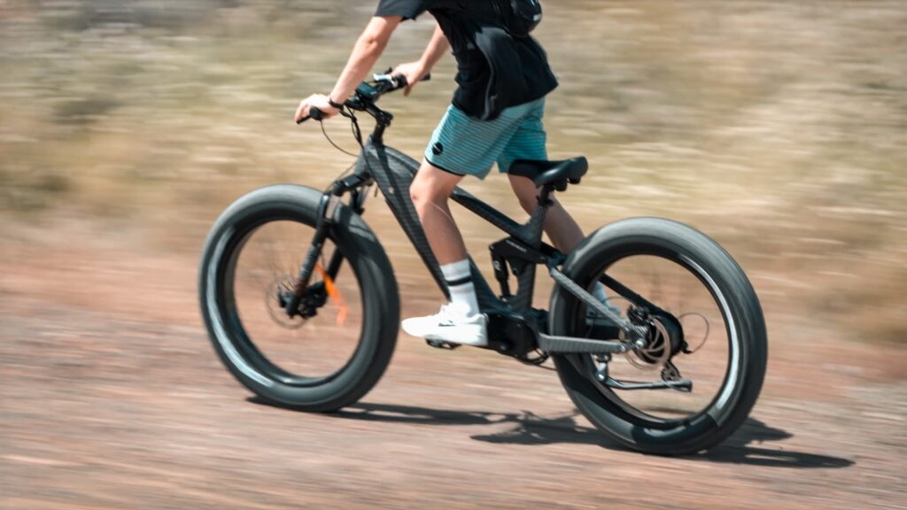 The Himiway Cobra eBike on a rugged trail, highlighting its 750W geared hub motor, 26*4.8 Super Fat Tires, and Shimano 7-speed gear shift system, ready for adventure.