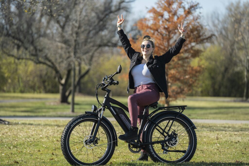 woman in black jacket and pink skirt riding on black bicycle during daytime woman in black jacket and pink skirt riding on black bicycle during daytime