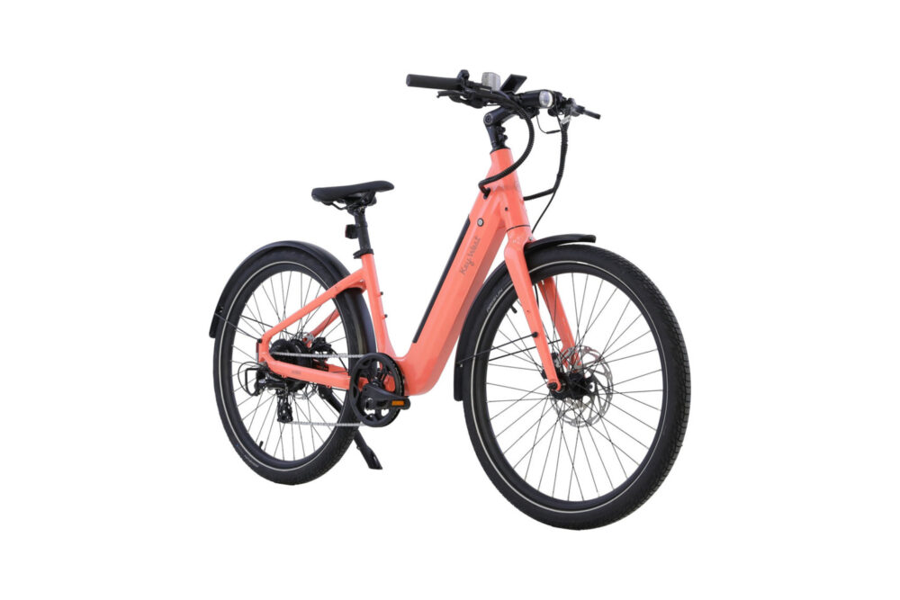 Key West Ebike in Coral Blush color parked on a beach boardwalk with palm trees in background