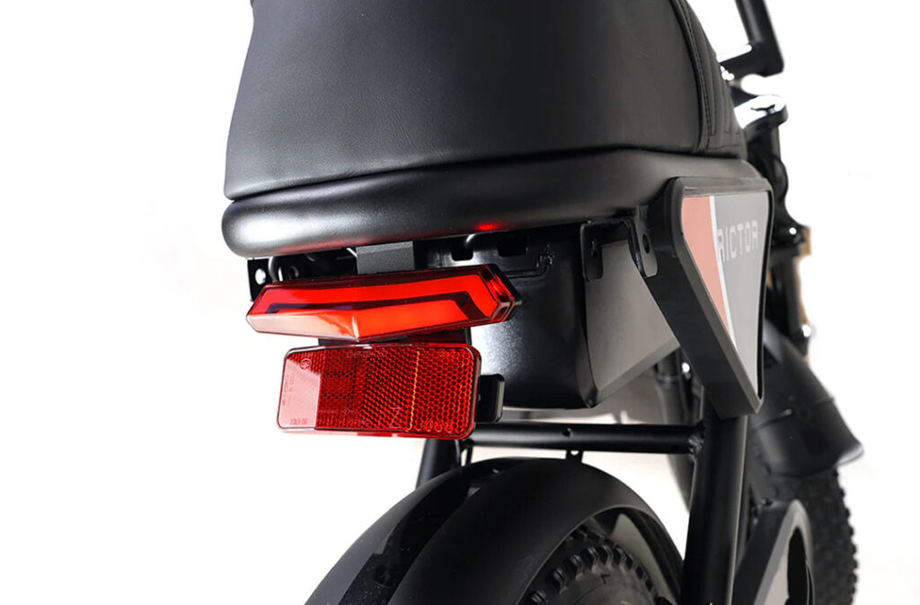 Young rider performing a wheelie on the Rictor Flexx eBike in a park setting